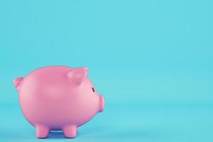 Pink piggy bank isolated on cyan background photo