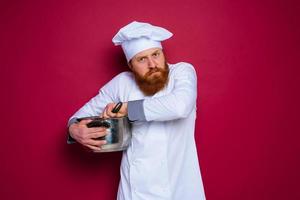 cocinero con barba y rojo delantal es celoso de su receta foto
