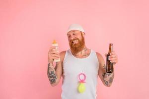 Thoughtful man with beard and tattoos acts like a newborn but wants a beer photo
