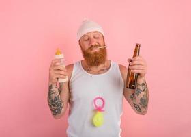 Thoughtful man with beard and tattoos acts like a newborn but wants a beer photo