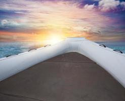 Inflatable boat at the sea during sunset photo