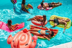 Friends in swimsuit in the pool getting a tan photo