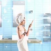 Woman with tattoo washes in the bathroom wrapped in a towel photo
