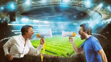 Supporters of opposing teams shout against each other with a megaphone at the stadium during a football match photo