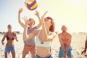 grupo de amigos jugando a playa voleo a el playa foto