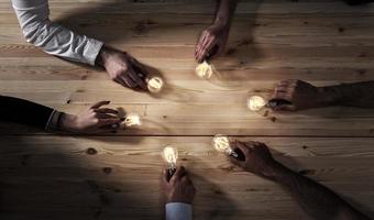 trabajo en equipo y lluvia de ideas concepto con empresarios ese compartir un idea con un lámpara. concepto de puesta en marcha foto