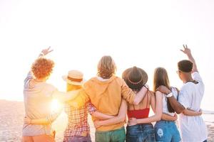 grupo de contento amigos teniendo divertido a Oceano playa foto