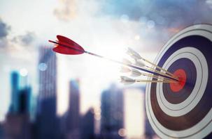 Arrow hit the center of target with modern skyscraper background. Business target achievement concept. 3D Rendering photo