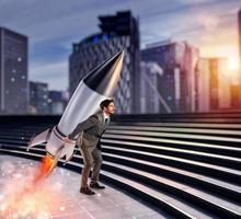 Determination and power businessman that holds a rocket. Startup concept photo