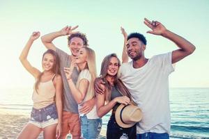 Group of friends having fun on the beach. Concept of summertime photo