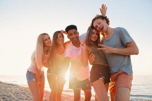 Group of friends having fun on the beach. Concept of summertime photo