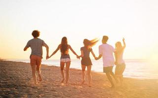 grupo de amigos correr en el mar. concepto de Hora de verano foto