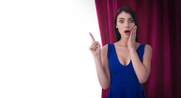 Pretty woman in front of red curtains indicates something about the theater show. Isolated on white background photo