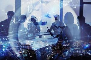 Network background concept with business people silhouette and city skyline at night. Double exposure and network effects photo