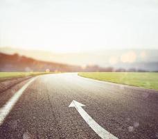 Road with arrow sign pointing the way photo