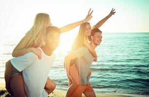 Happy smiling couples playing at the beach photo