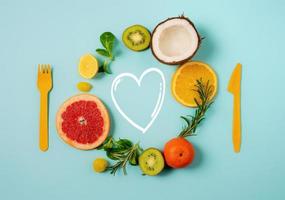 Composition of citrus fruit, orange and lemon, coconut, kiwi on cyan background photo