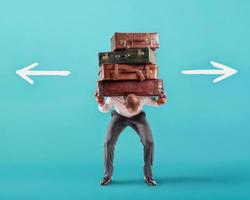 Man with a lot of luggages is confused about the right destination photo