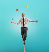 Worry man in balance walking on a rope overand acts like a juggler photo