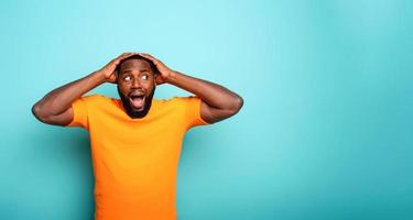 Amazed and shocked expression of a boy over cyan background photo