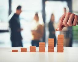 Businessman puts a brick on a bricks pile. Concept of growing statistics and success photo