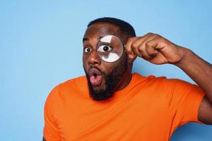 Man search something with a magnifier lens with surprised expression photo