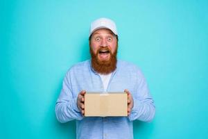 Courier with carton box in hand is surprised about something photo