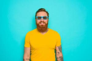 Man with yellow t-shirt and beard is very happy photo