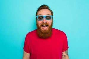 Man with beard and sunglasses is wondered and happy photo