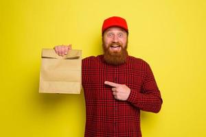 Delivery man with hat and beard has an happy expression photo