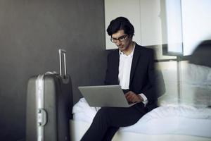 Businessman ready to travel works with his laptop photo