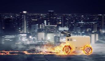 Priority Cardboard box with racing wheels on fire. Fast shipping by road. photo
