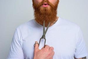 Wondered man with scissors is ready to cut the beard photo