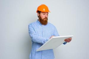 Confidant architect with beard and orange helmet does a sketch photo