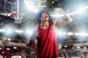 baloncesto jugador gana el partido a el cesta estadio lleno de público. foto