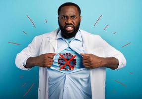 Medic acts like a superhero to fight pandemic of covid19 coronaviruses. Blue background photo