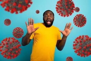 Fearful expression of a boy who is scared to catch the coronavirus. Cyan background. photo
