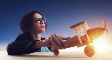 Woman with vintage wooden toy plane dreams of achieving desired goals photo