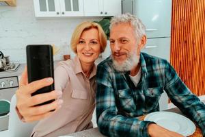 miling Pareja toma un selfie con un teléfono inteligente durante desayuno foto