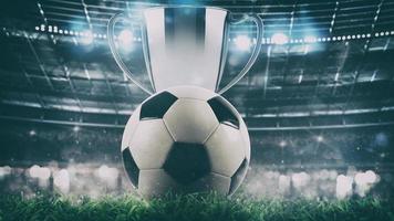 Close up of a soccer ball with trophy in the center of the stadium illuminated by the headlights photo