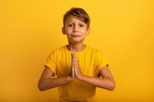 niño es Suplicando porque él tiene alguna cosa a pedido. amarillo antecedentes foto