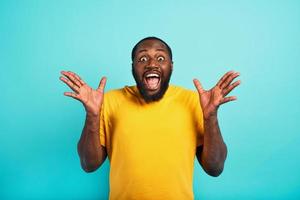 Man is surprised and excited about something. cyan background photo