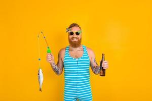 hombre con barba y traje de baño atrapado un pescado foto