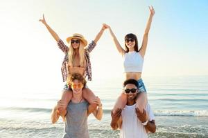 Happy smiling couples playing at the beach photo