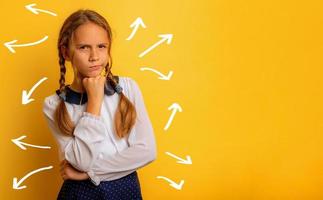 Young student has some doubt about something. yellow background photo