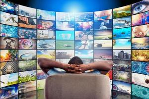 Man has fun watching a film and relaxing on a armchair. Concept of entertainment and streaming tv. photo