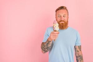 Hungry man with beard and tattoos eats a big icecream photo