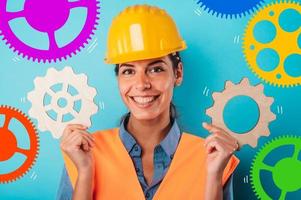 Woman with helmet join pieces of gears as concept of partnership and integration photo