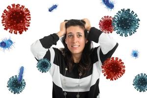 Feared girl attacked by viruses and bacteria. Concept of illness photo