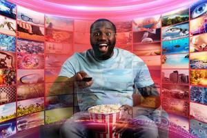 Boy has fun watching a film. Concept of entertainment and streaming tv. red background photo